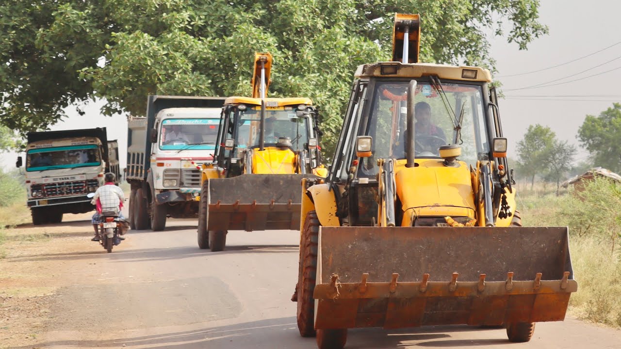 JCB Backhoe Loading Mud in Double Tata Truck For Making a Waste Land into a Farm