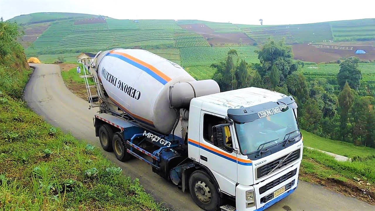Volvo Ready Mix Cement Truck Working Pouring Concrete On Hill Road Construction