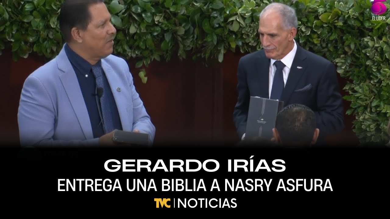Gerardo Irías, presidente de la Confraternidad Evangélica, le entrega una biblia a Nasry Asfura