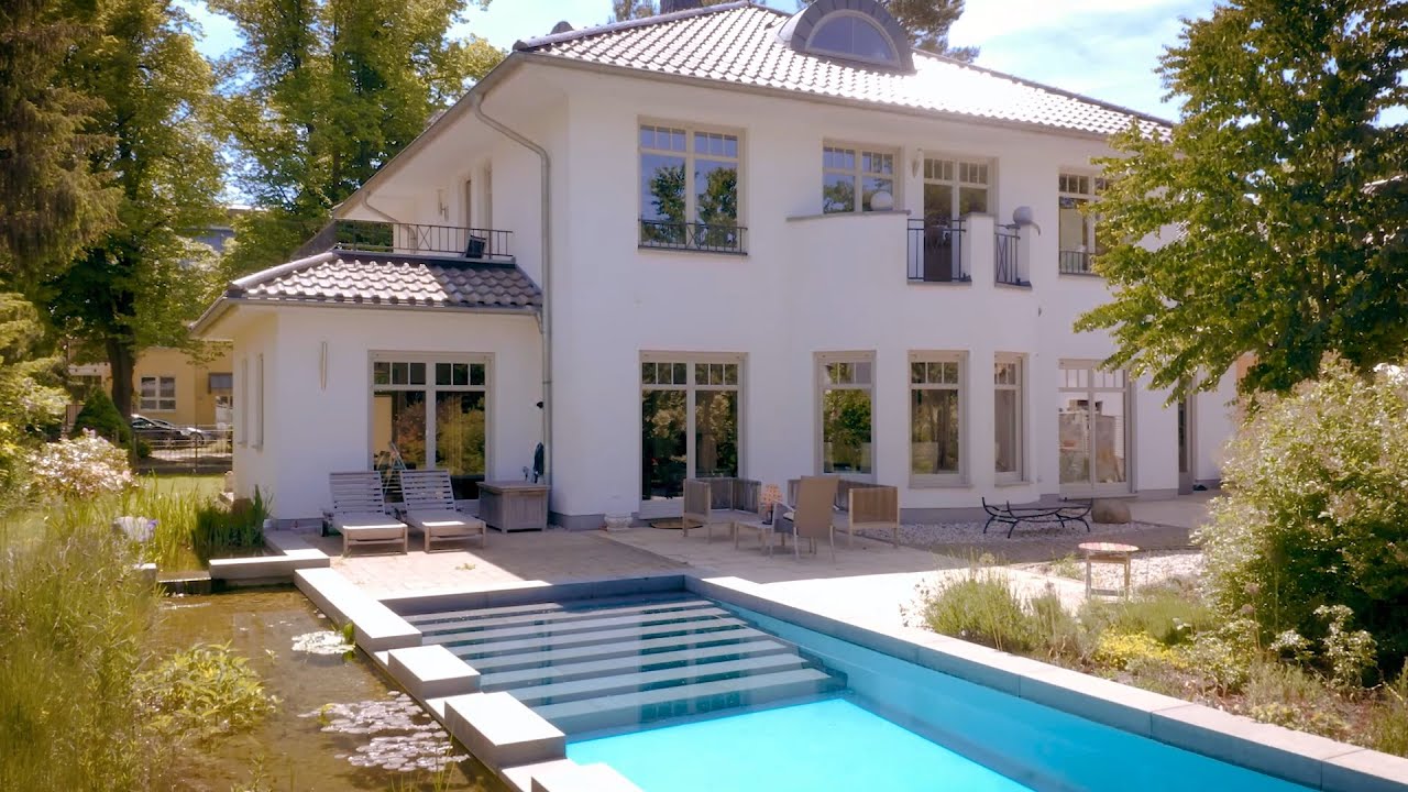 Klassiche Stadtvilla mit Anbauten, Tonnengaube, Runderker und Naturpool von ARGE-HAUS GmbH