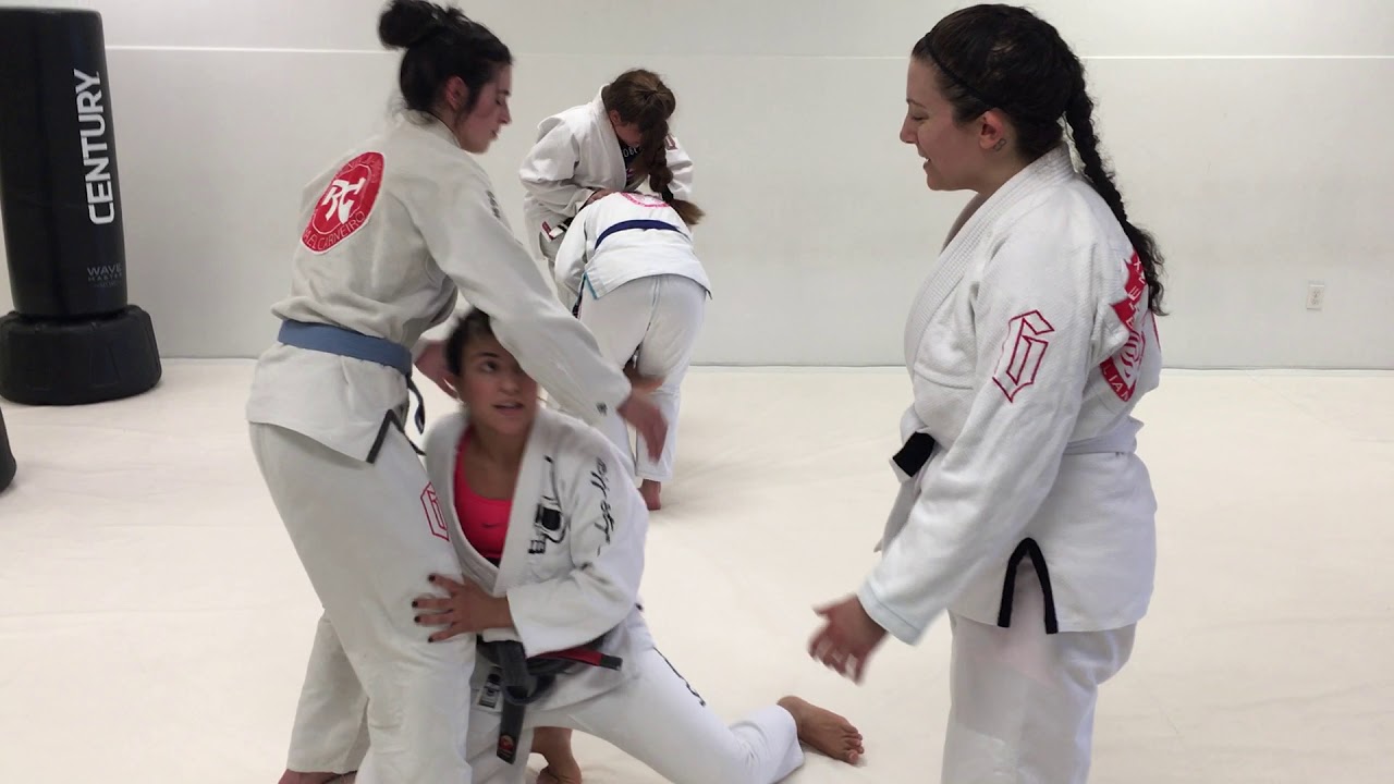 Women's Brazilian Jiu Jitsu class practices single-leg takedowns