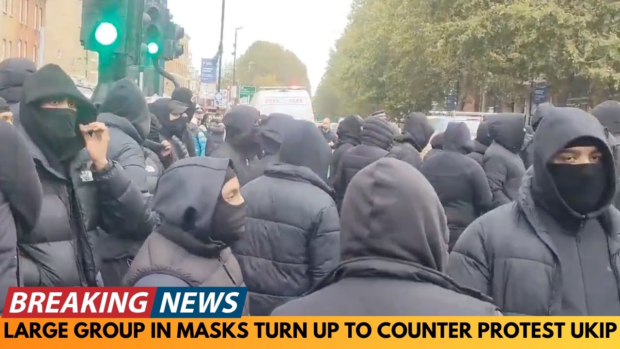 БОЛЬШАЯ ГРУППА ЛЮДЕЙ В МАСКАХ ВЫШЛА НА КОНТРОЛЬ ПРОТЕСТА UKIP В УАЙЧЕПЕЛЕ