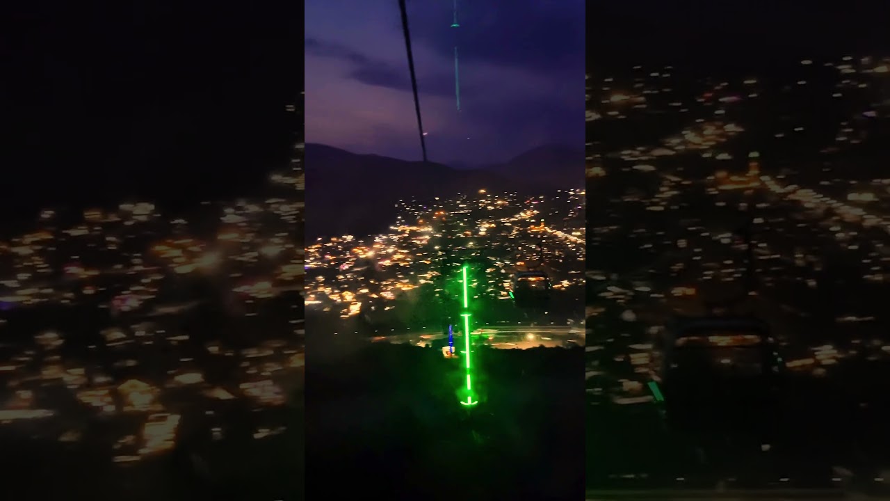 Night view from the cable car - a town between mountains. 