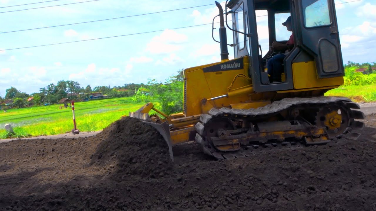 Komatsu D21P Mini Dozer Grading gravel on a busy road