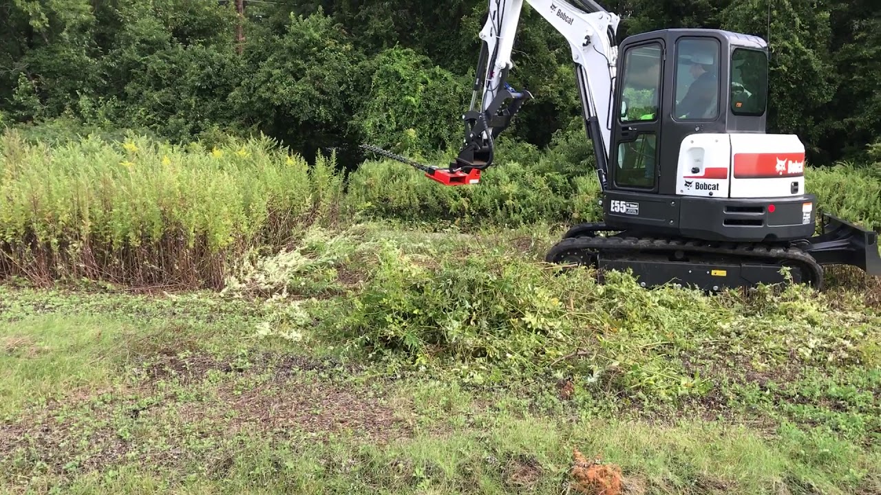 Trimming near landfill swale with our excavator and sickle bar mower attachment