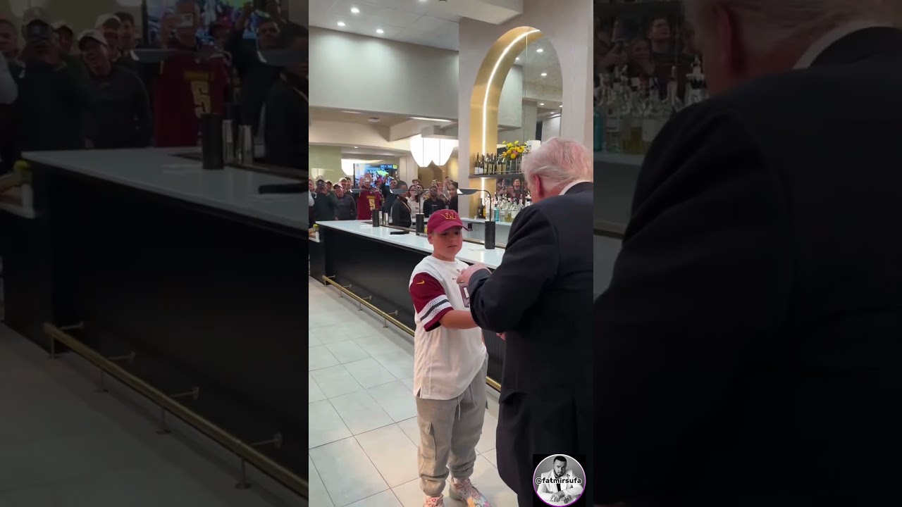 President Trump hands a young boy his presidential challenge coin as he's leaving the Washington