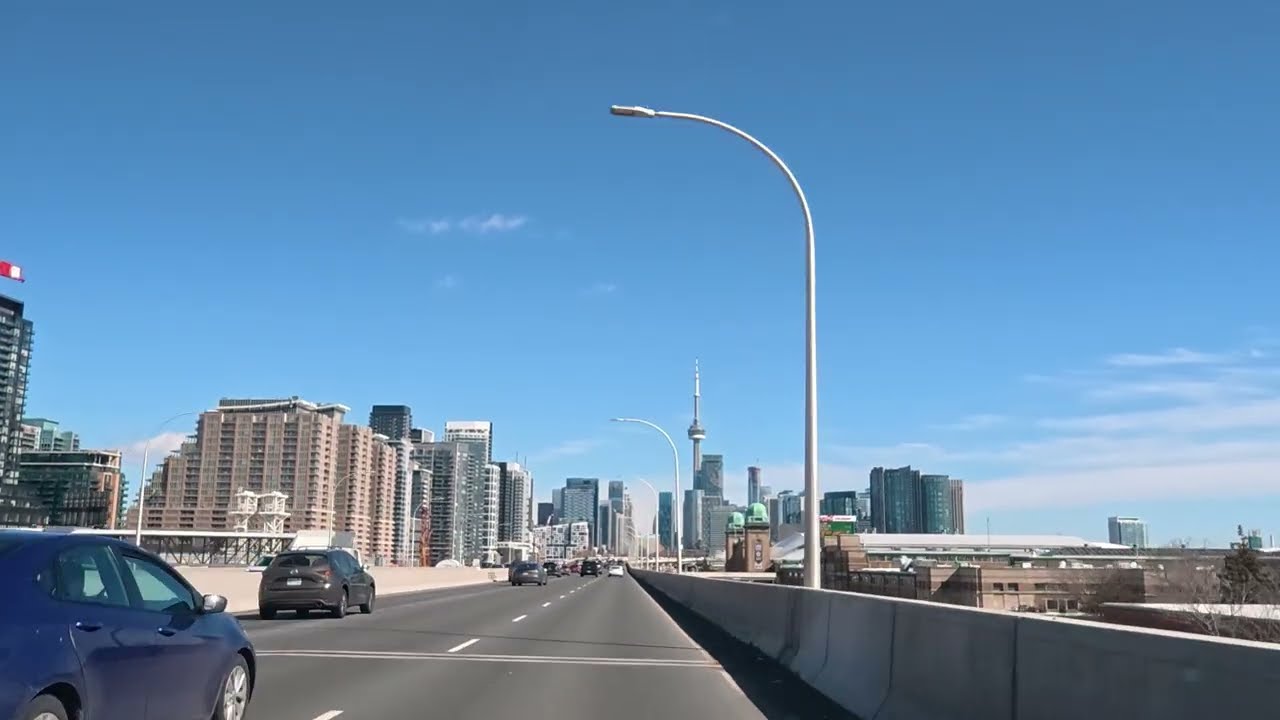 Driving on a highway through tall buildings.