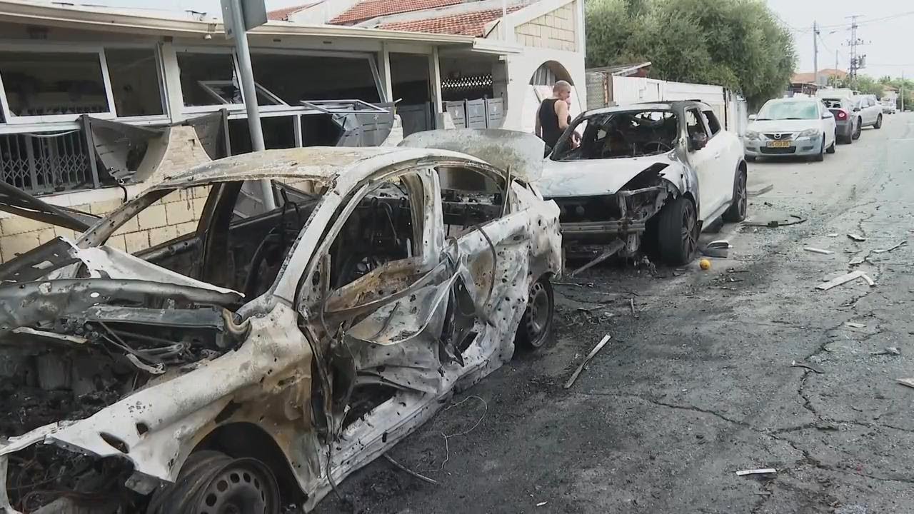 Aftermath of militant rocket attack in southern Israeli city of Ashkelon shows damaged vehicles and