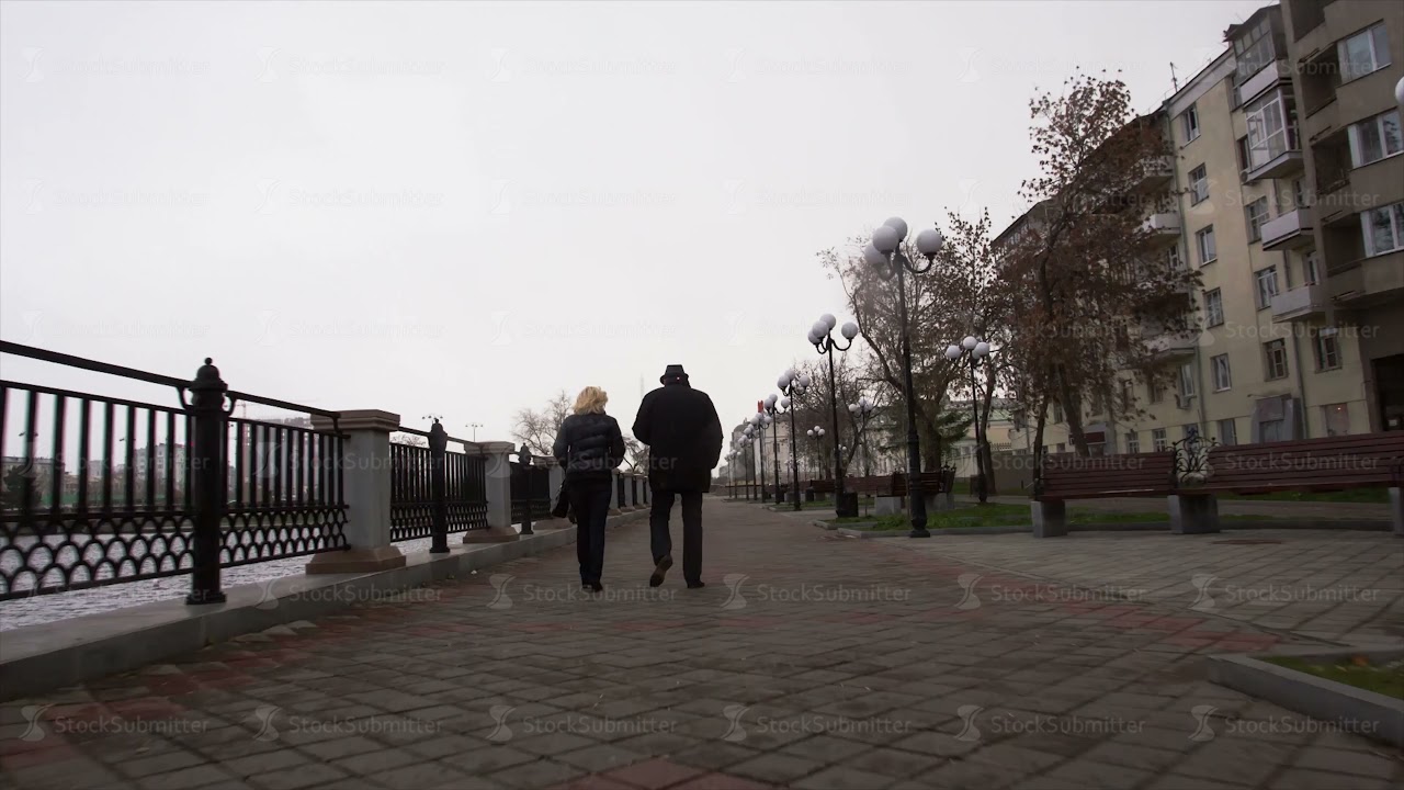 Romantic couple walking together. Video. An elderly couple walks in the city on a cloudy day