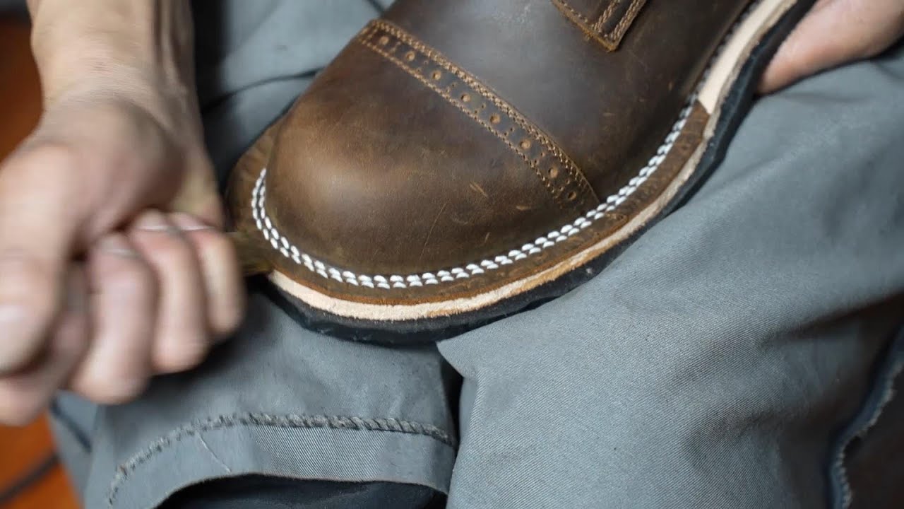The process of making handmade work boots. Hands of craftsmen who make handmade shoes all their live