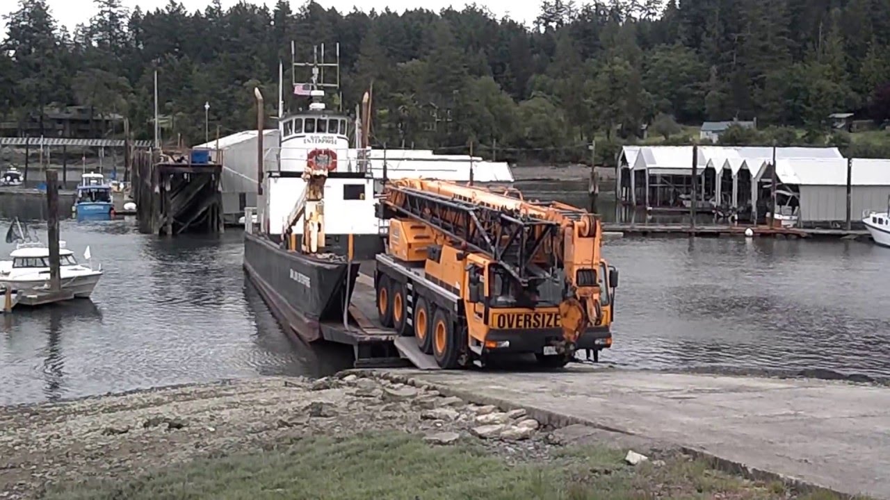 Giant truck crane BACKS onto small landing craft.