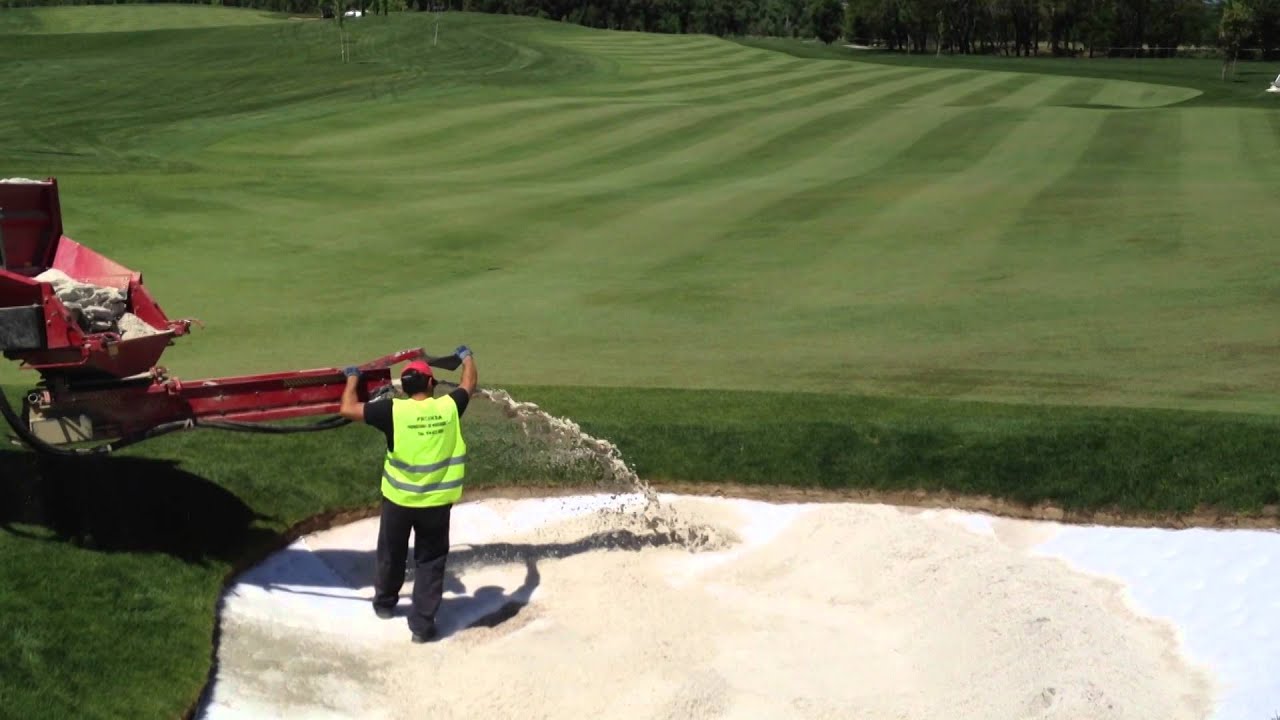 Descarga de arena en bunker mediante recebadora / Bunker sand installation with fairway topdresser