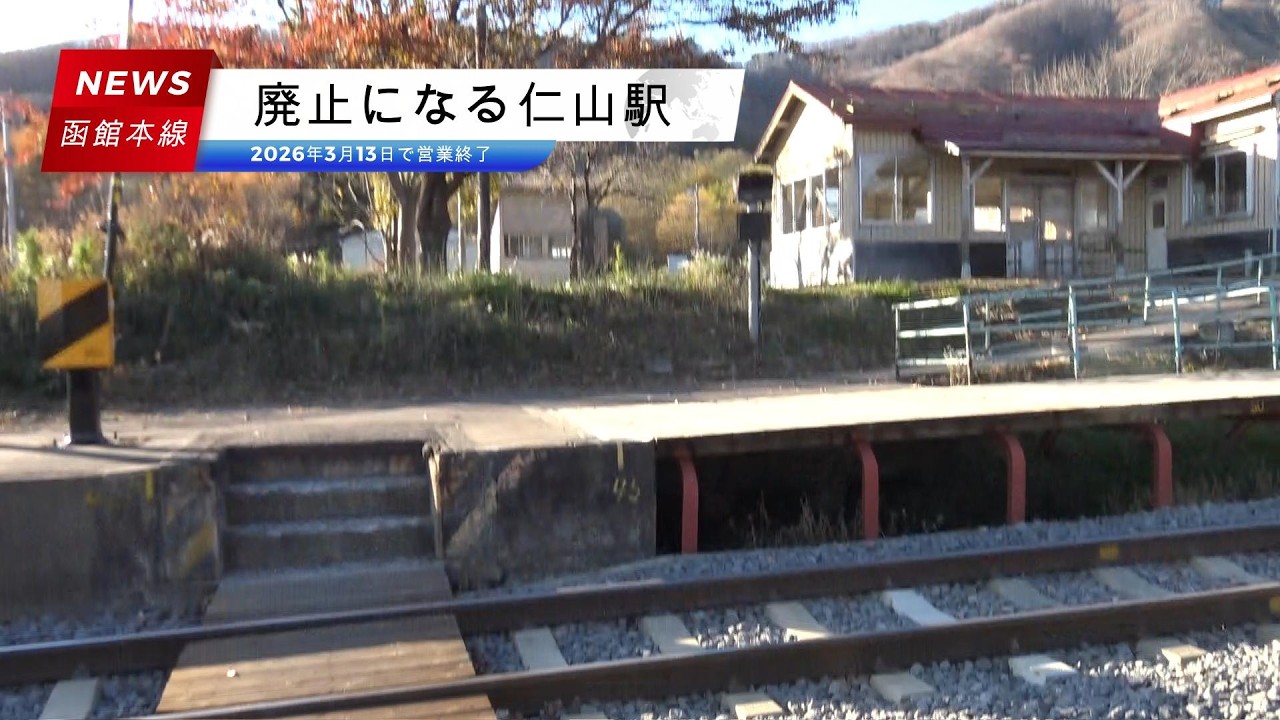 廃止になる函館本線仁山駅 秋色の木々に囲まれたホーム間の構内踏切を渡る