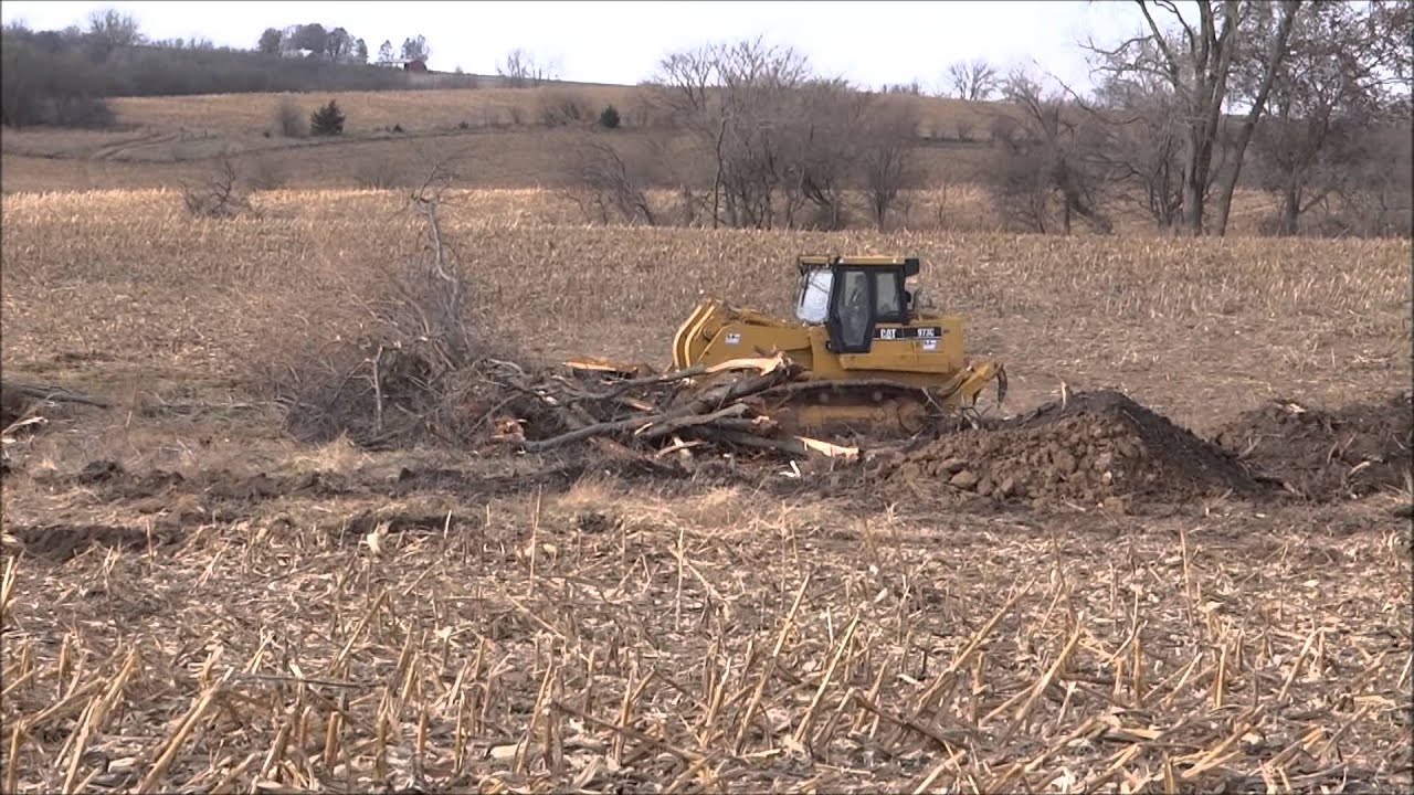 CAT 973C Crawler Loader pushing and stacking trees