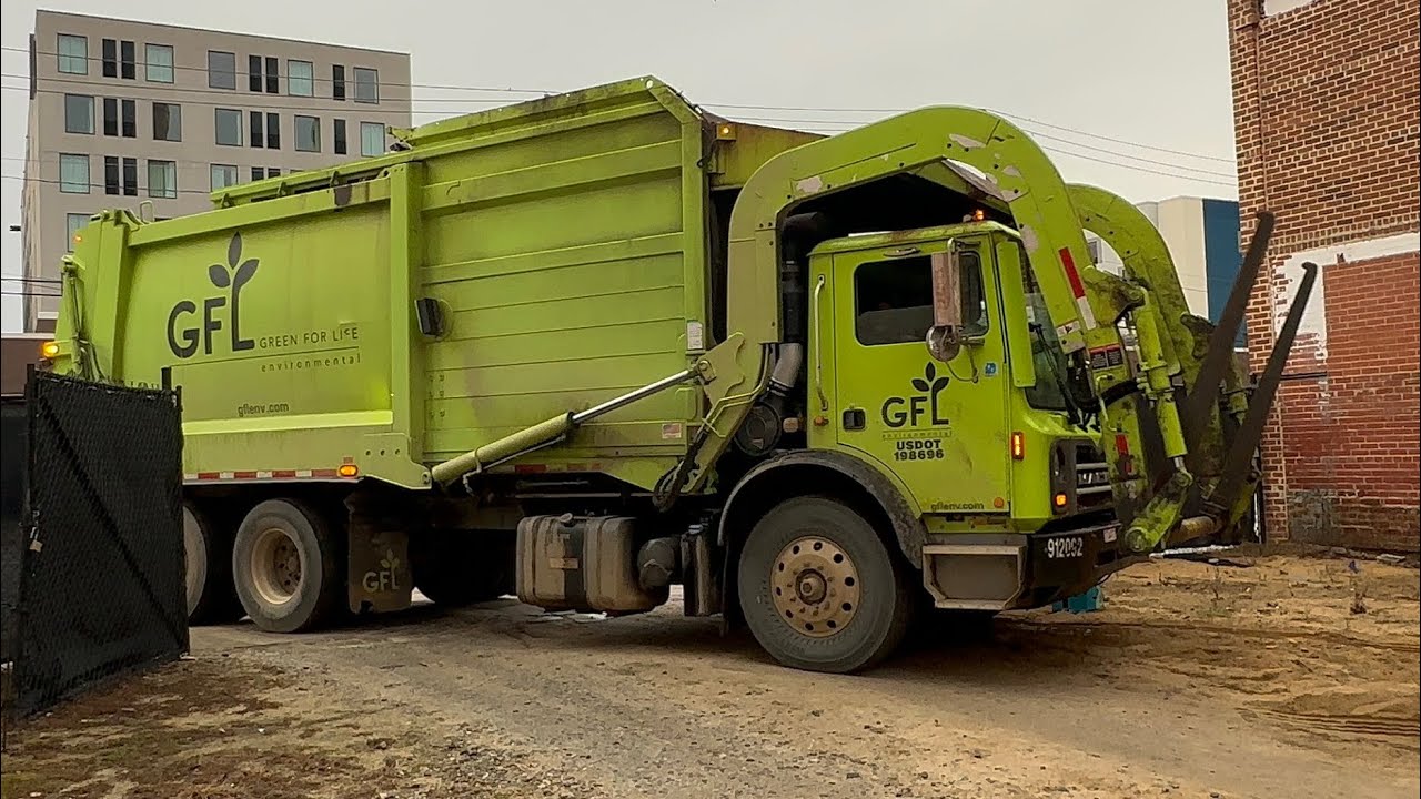 GFL Environmental Mack MRU heil garbage trucks dumping dumpsters in the rain 
