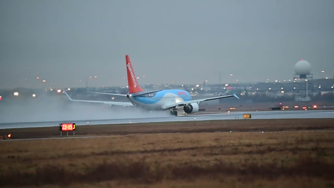 Sunwing 737 Max 8 winter lease from TUI speeding up to take off from wet Toronto on last day of 2022