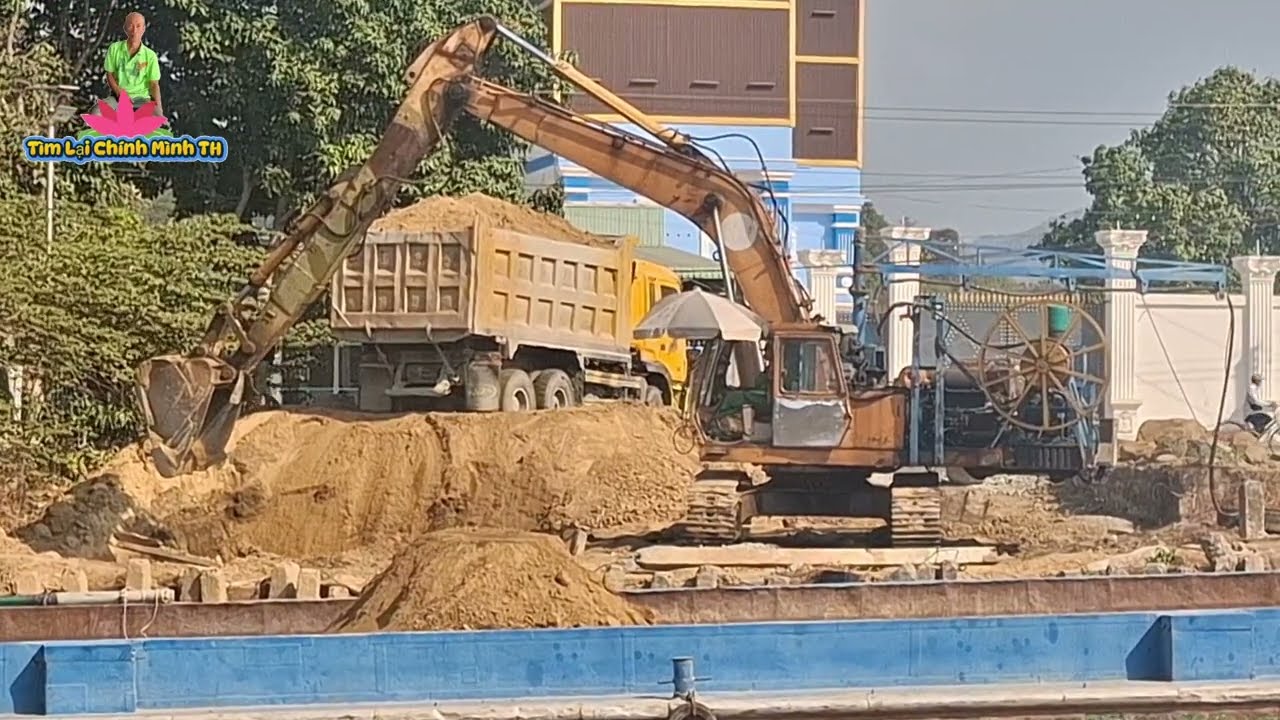 xe ben de lại đổ đất cho tê y mút đất xuống xà lan