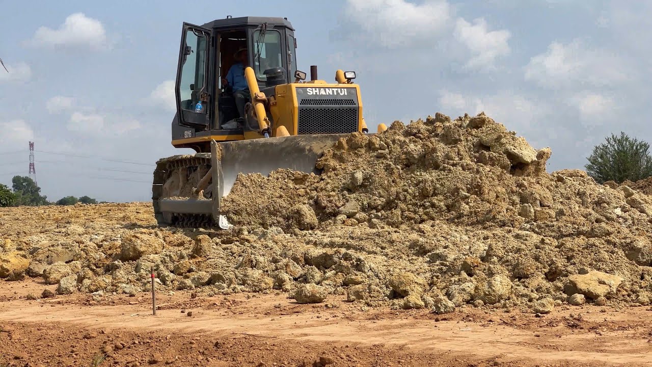 Extreme Bulldozer pushing soil spreading road building operation SHANTUI SD16