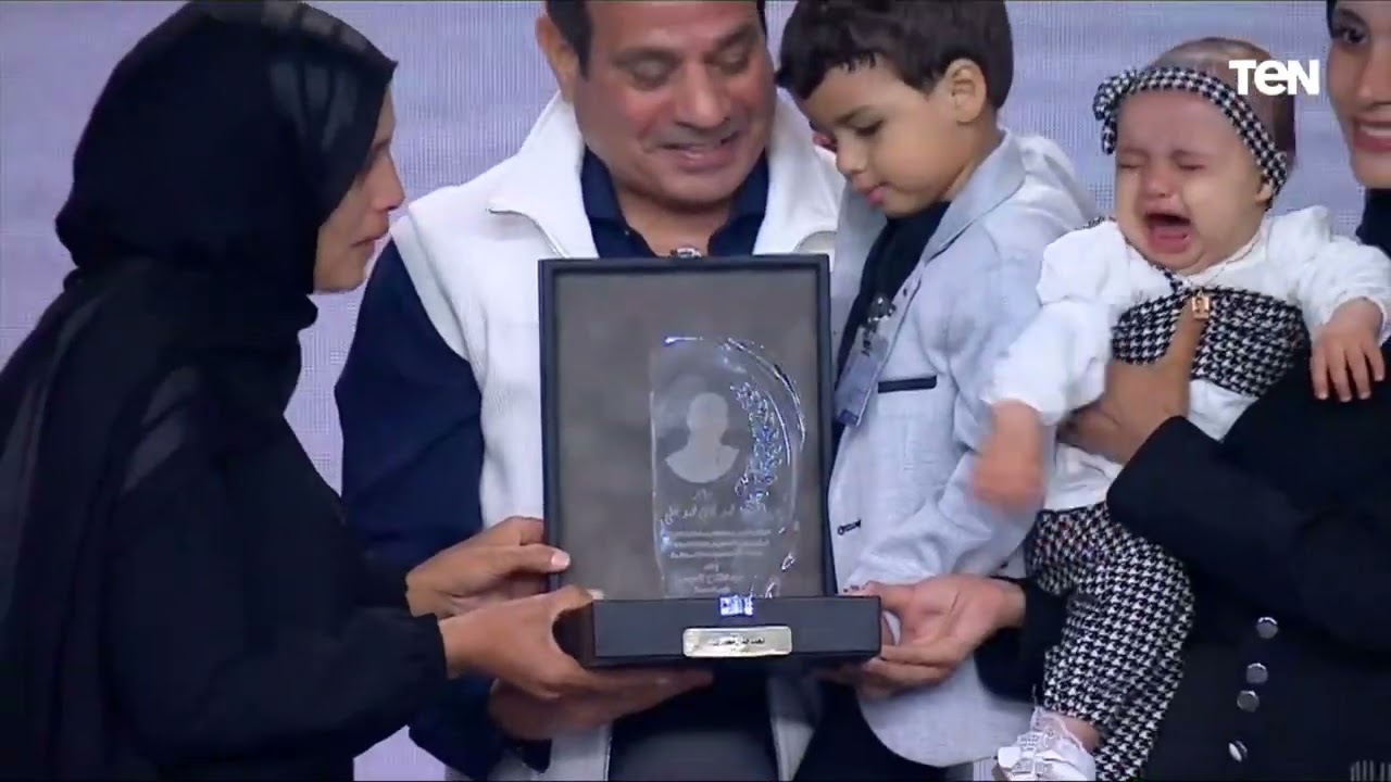 الرئيس الأب.. السيسي يحمل طفل خلال تكريمه والده الشهيد
