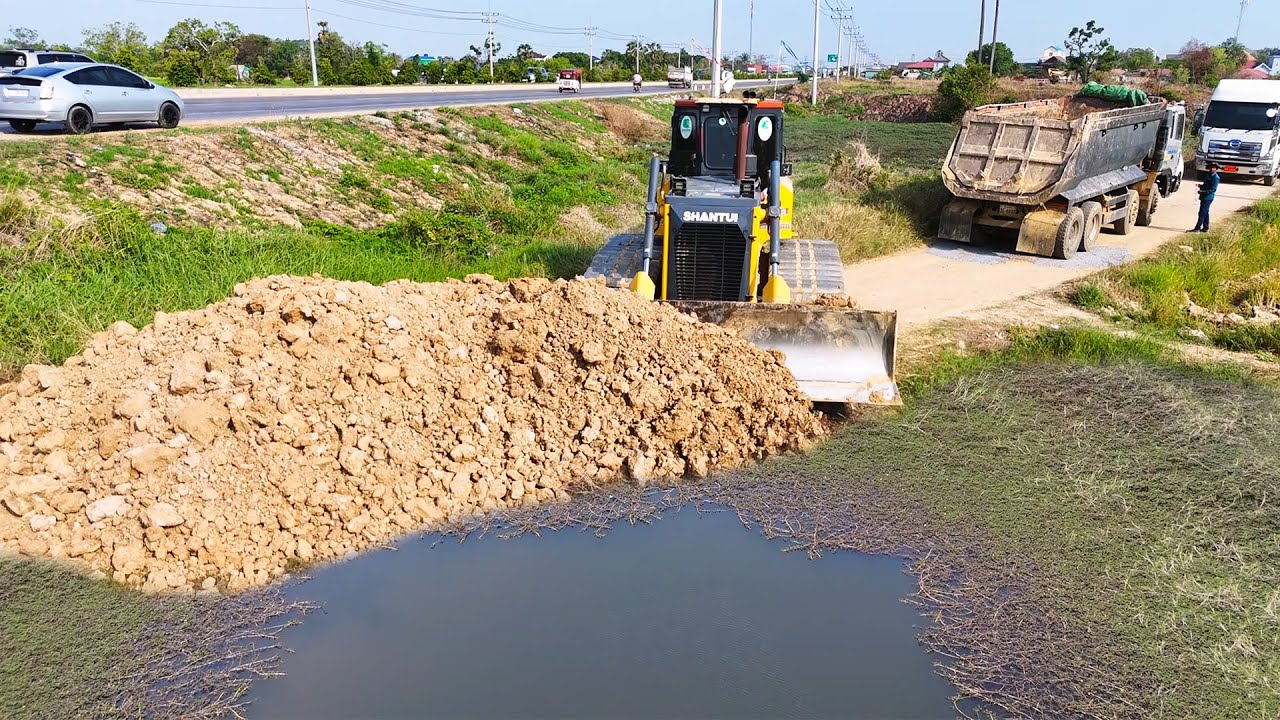Amazing bulldozer pushing soil filling up land with dump trucks