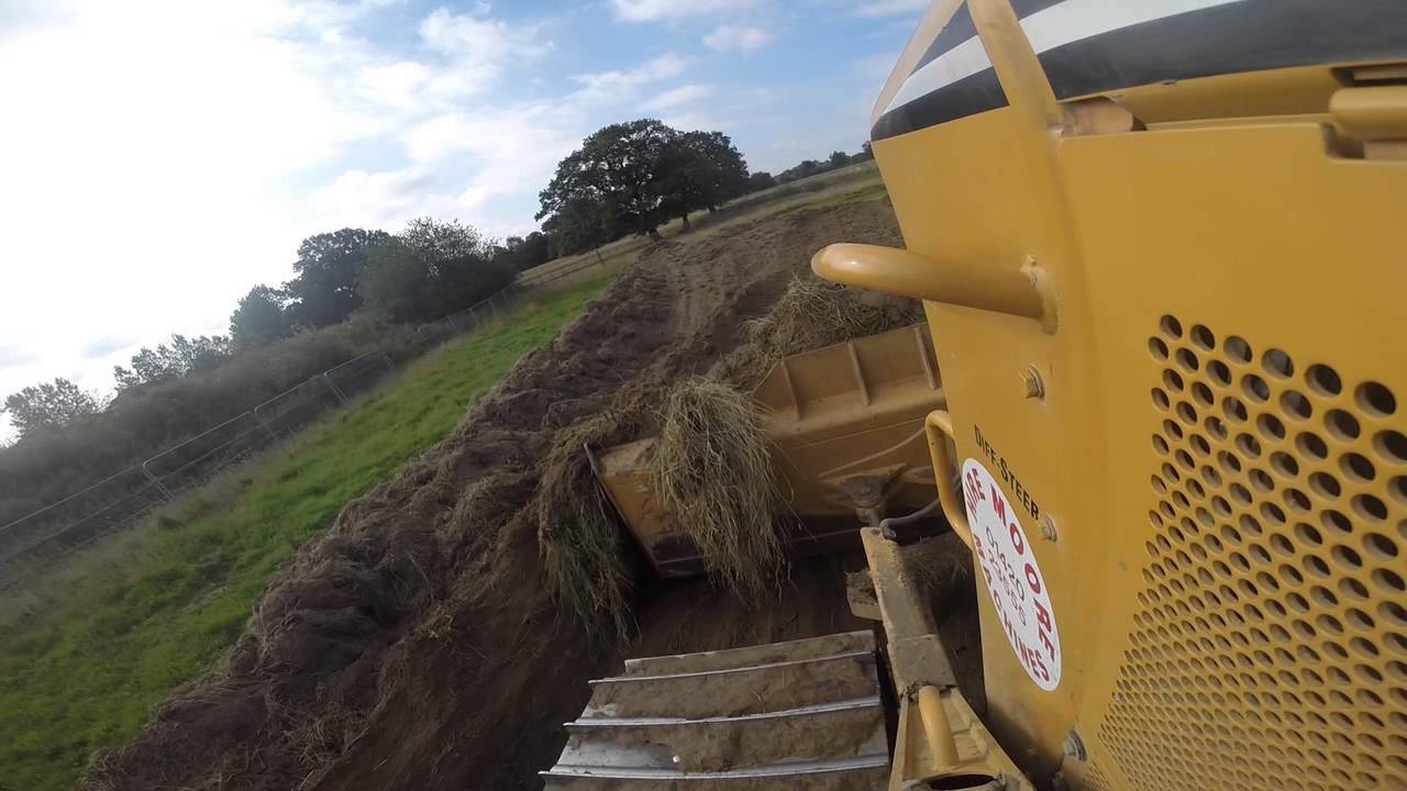 Moore's Cat D6N Dozer pushing grass down to fill area