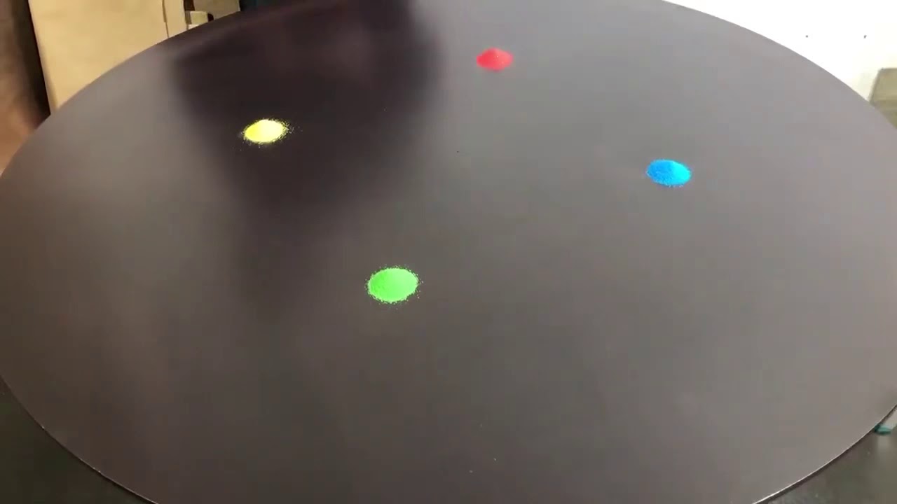 Japanese artist Kenichi Kanazawa manipulating sand on a steel tabletop.