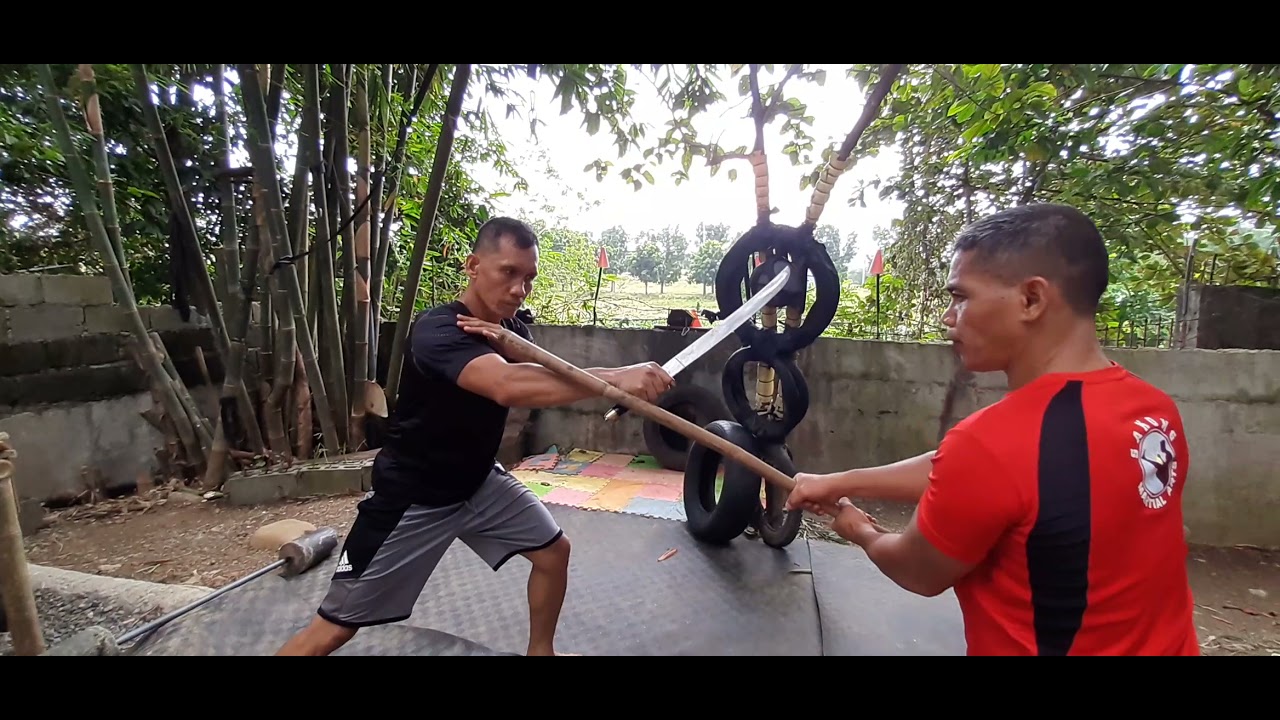How to defend yourself against a machete by using a long stick.