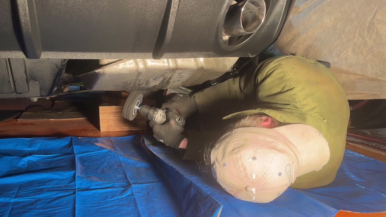 Removing undercoating from the passenger side muffler 
