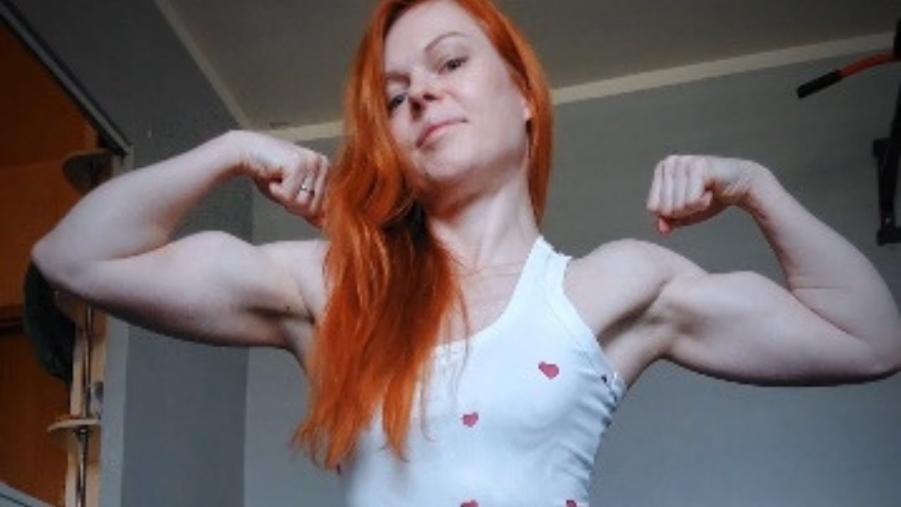 Beautiful redhead girl shows off her defined biceps!