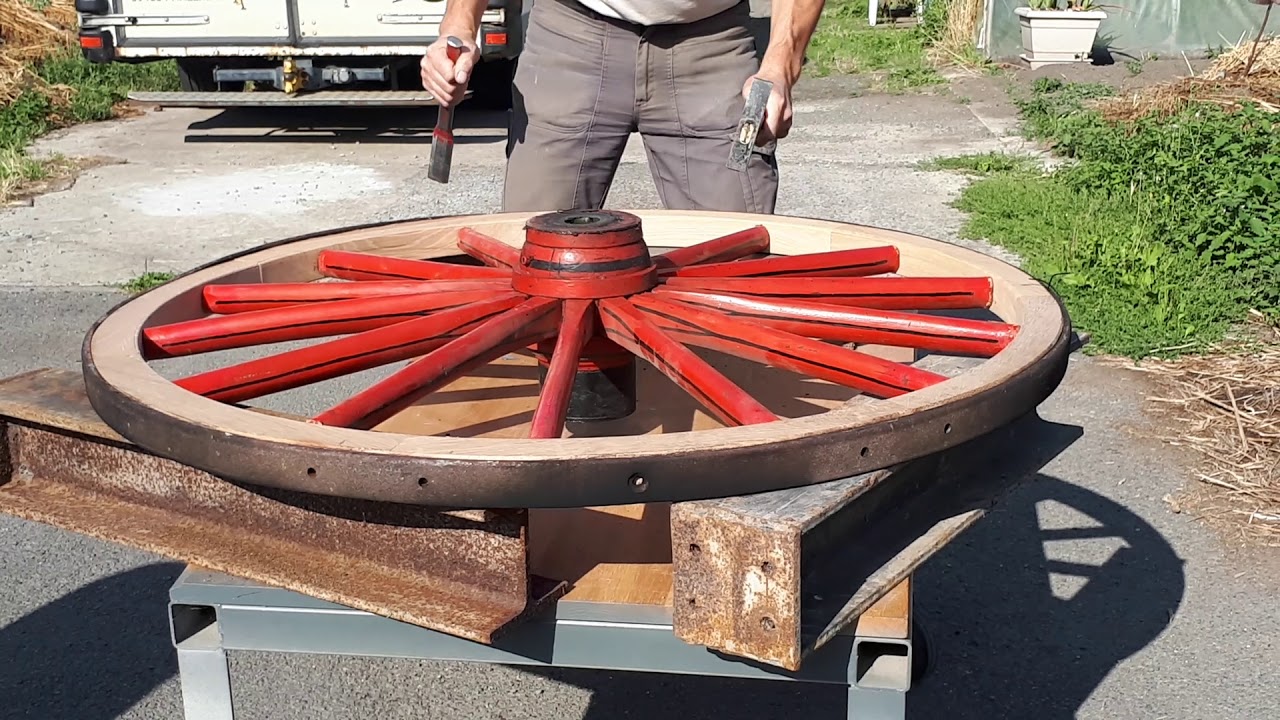 Réparation d'une roue de calèche en bois