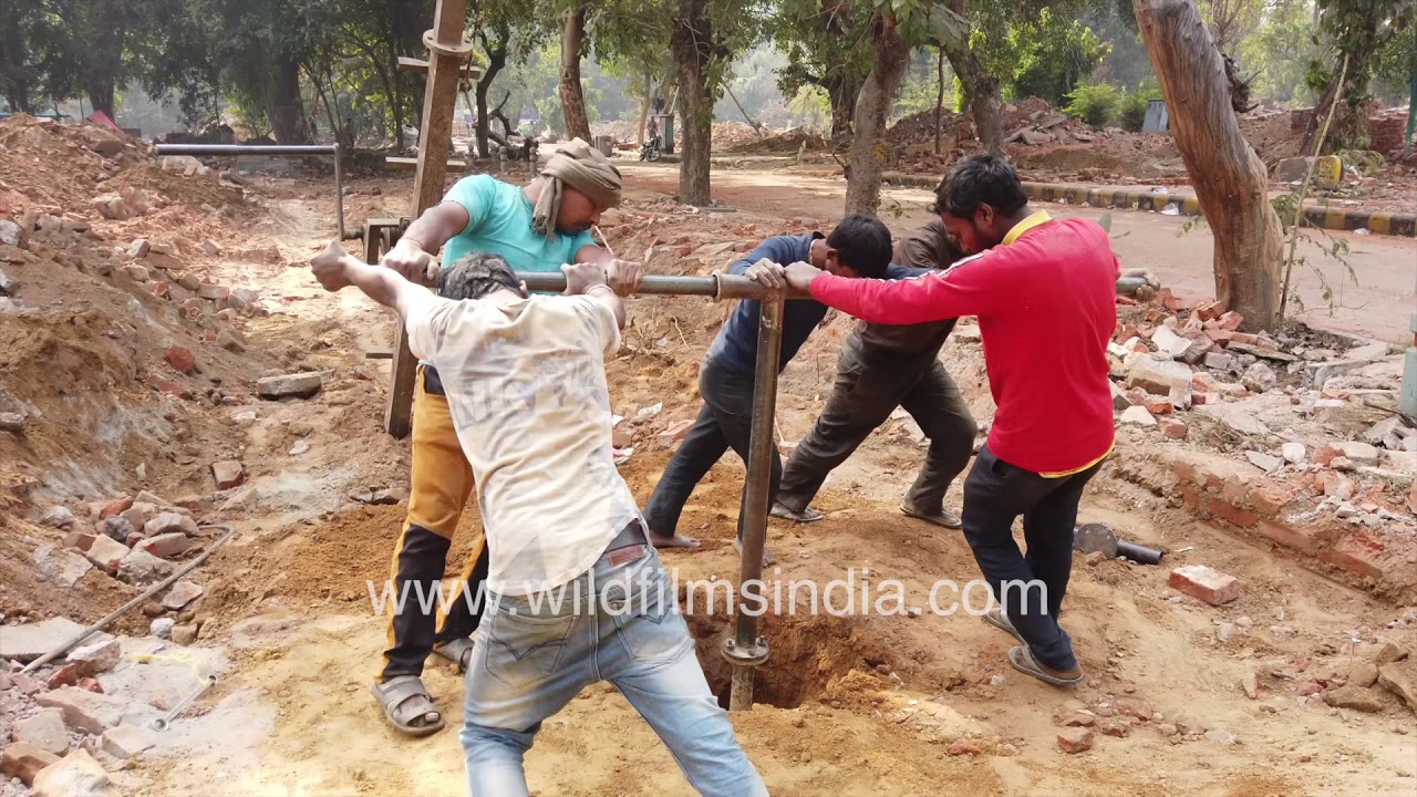 Borewell manual drilling in close up | Road Construction | Manual labourers at work