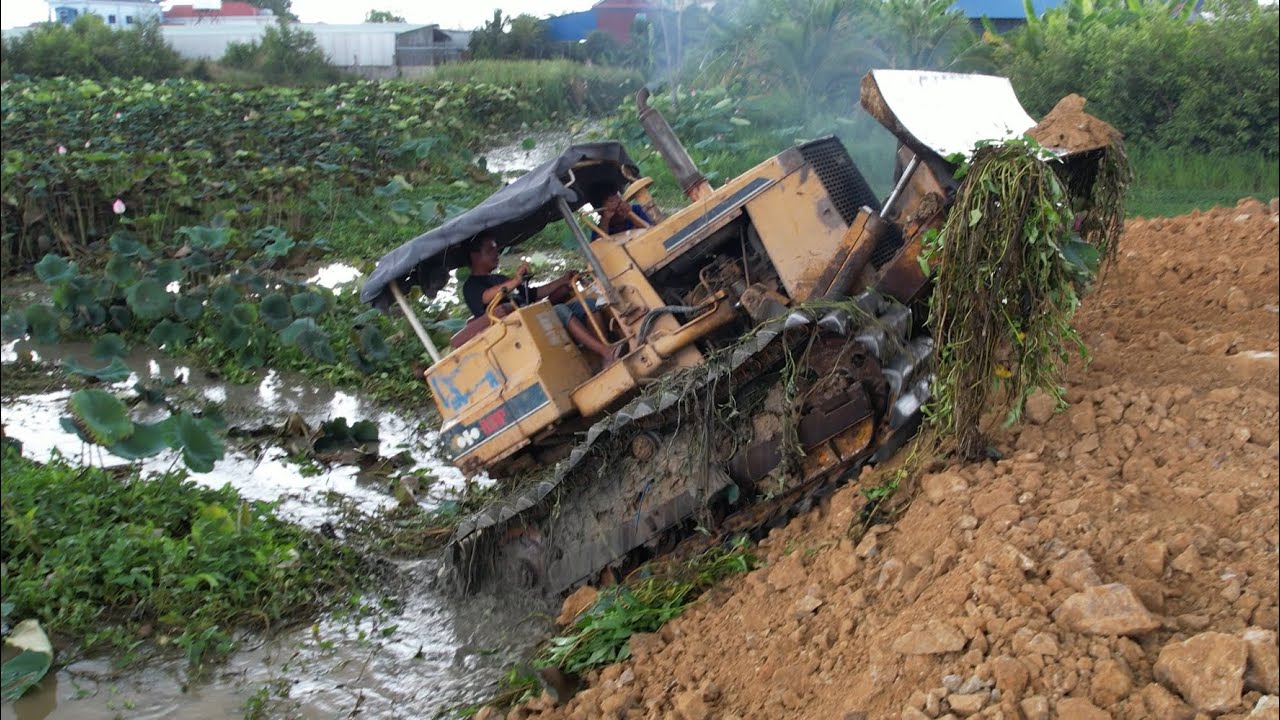 Incredible Skill operator bulldozer working push soil landfill flooded area & dump truck unloading