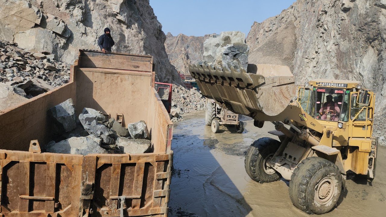 A Mega Rock Loading Show: Cat966D Loading Rocks in Dump Trucks and Trolleys