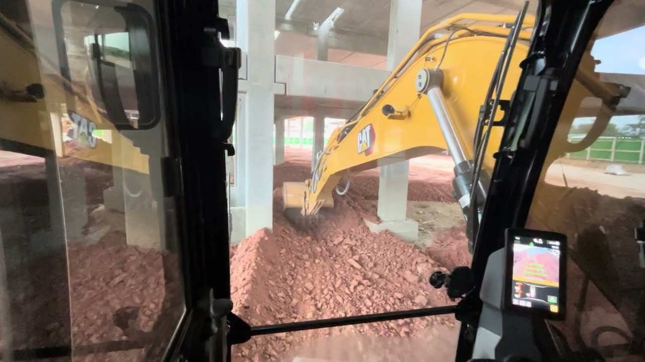 Escavadeira hidráulica aterrando piso galpão comercial. Com auxílio da retro escavadeira cat 416 
