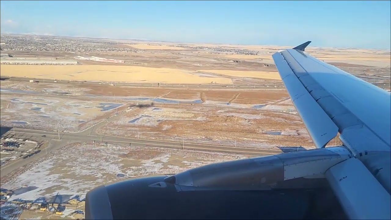 Descent and Landing with Snow Covered Rocky Mountains in the Distance