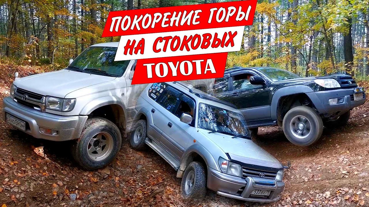 Стоковые Toyota Land Cruiser Prado и Hilux Surf поднимаются по каменистой размытой дороге на гору