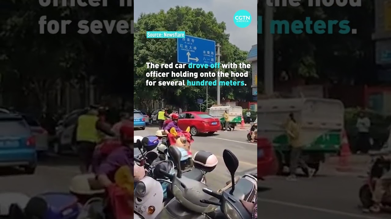 A car in China speeds with an enforcement officer hanging on its hood