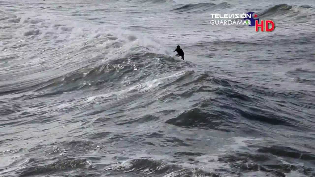 Surfistas en la playa de Guardamar junto desembocadura