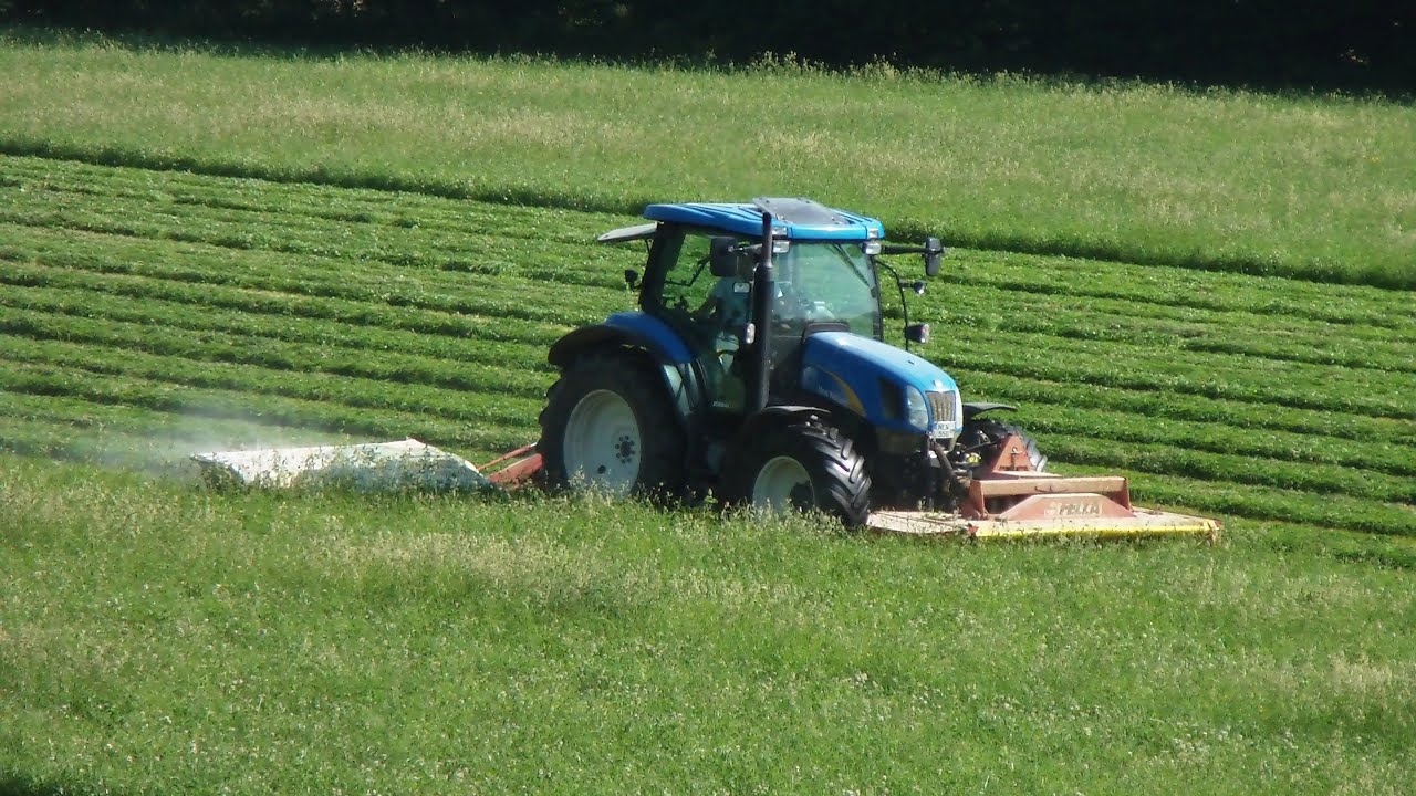 Heuernte Teil 1 New Holland Traktor mit Front- und Heck- Mähwerk in action cutting hay