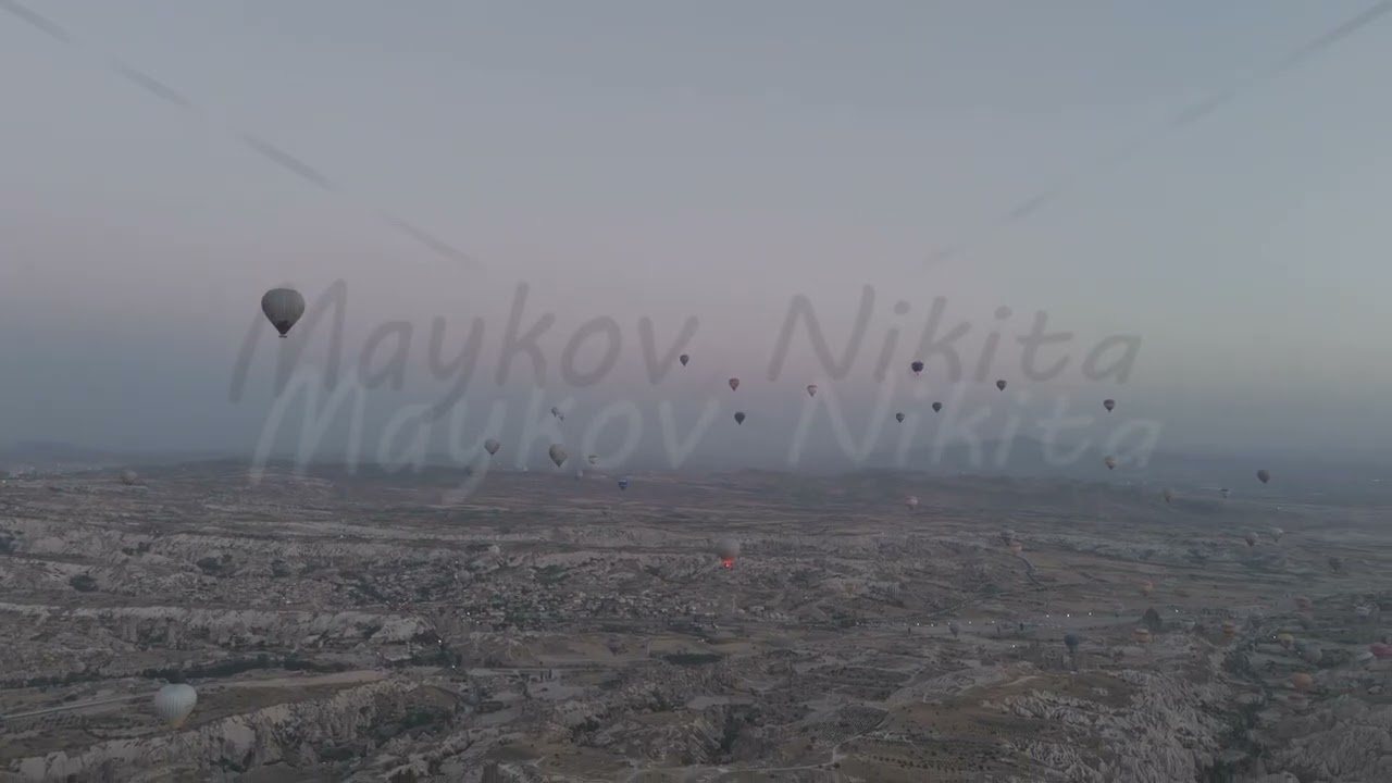 D-Log M. Goreme, Nevsehir, Turkey. Massive armada of hot air balloons with fire bursts flying at ...