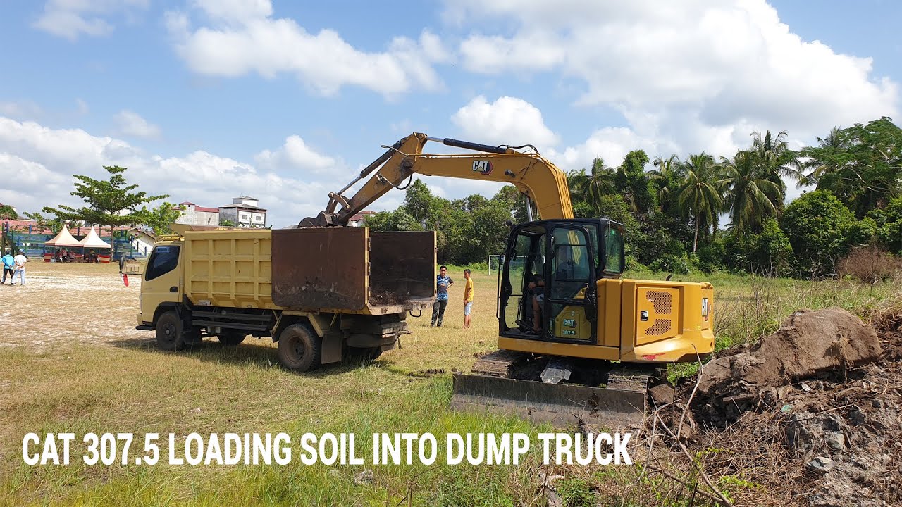 CAT 307.5 EXCAVATOR LOADING SOIL INTO DUMP TRUCK