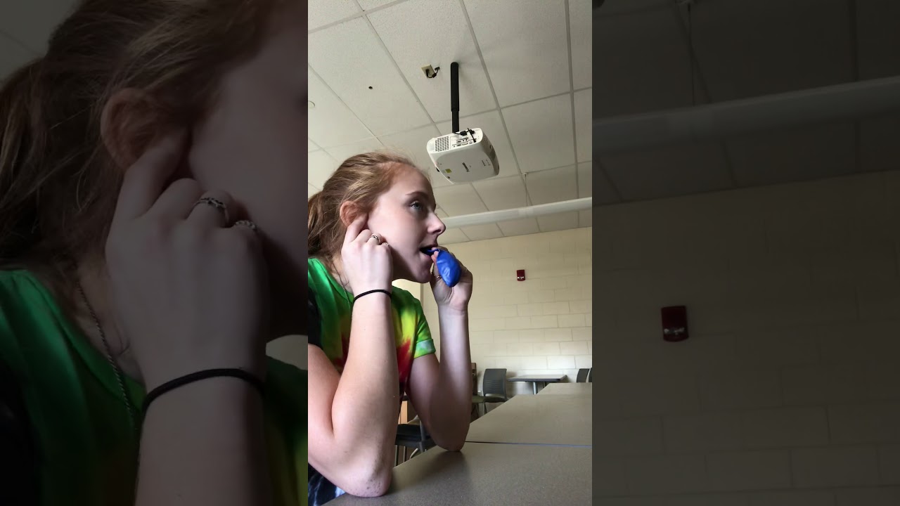 My friend blowing up a blue  balloon to  pop