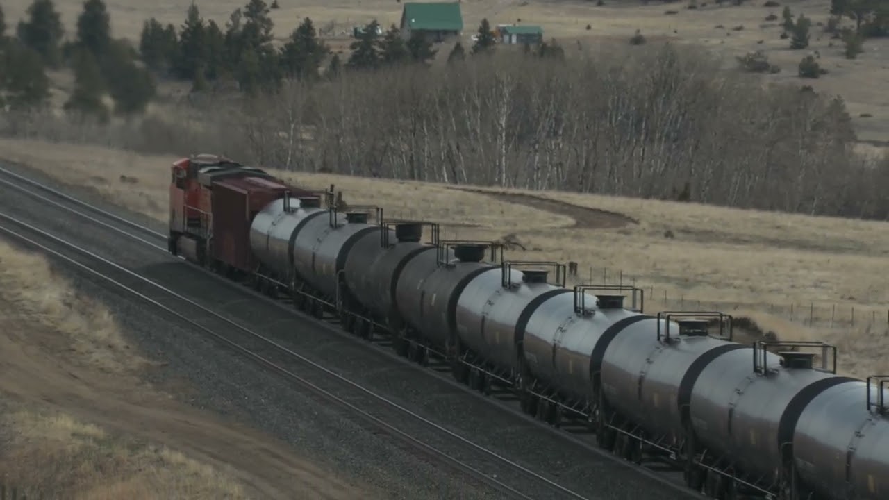 BNSF 6947 leads an EB oil train past Austin Mullan Pass