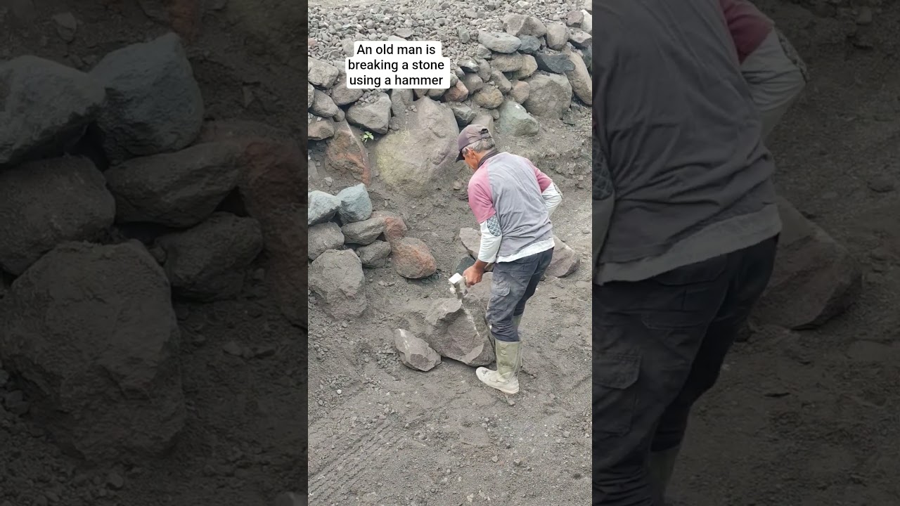 an old man is breaking a rock with a hammer