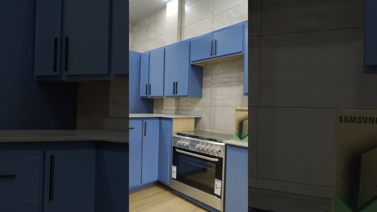 Cuisine en bois stratifi&eacute;, finition en bleu, plan de travail en granite.