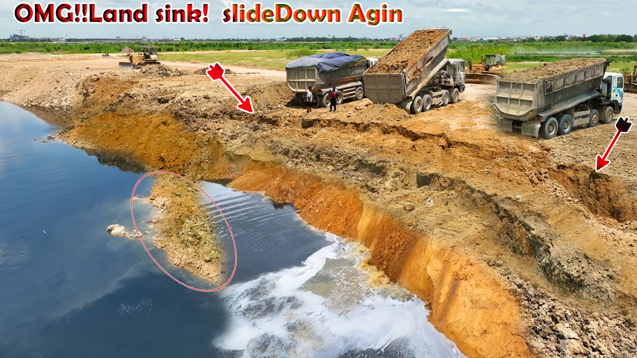 Incredible large landslide sinks again. Dozer KOMATSU  is trying to push the soil into deep water.