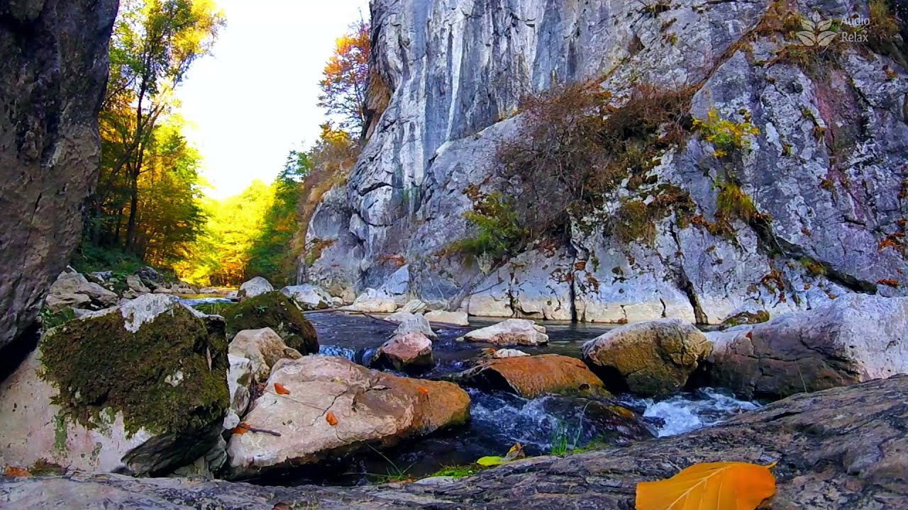 Красота природы. Горная река течет вдоль скалы.