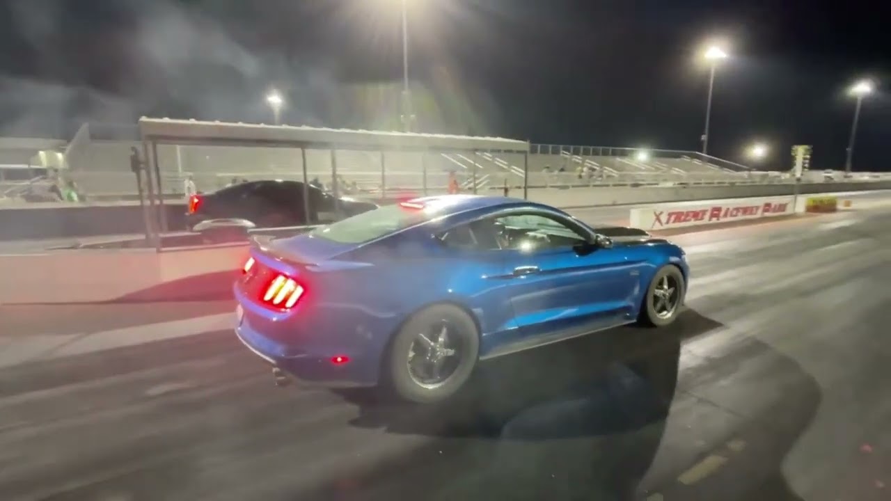 Соревнования по кольцевым гонкам на трассе Xtreme Raceway Park под светом прожекторов.