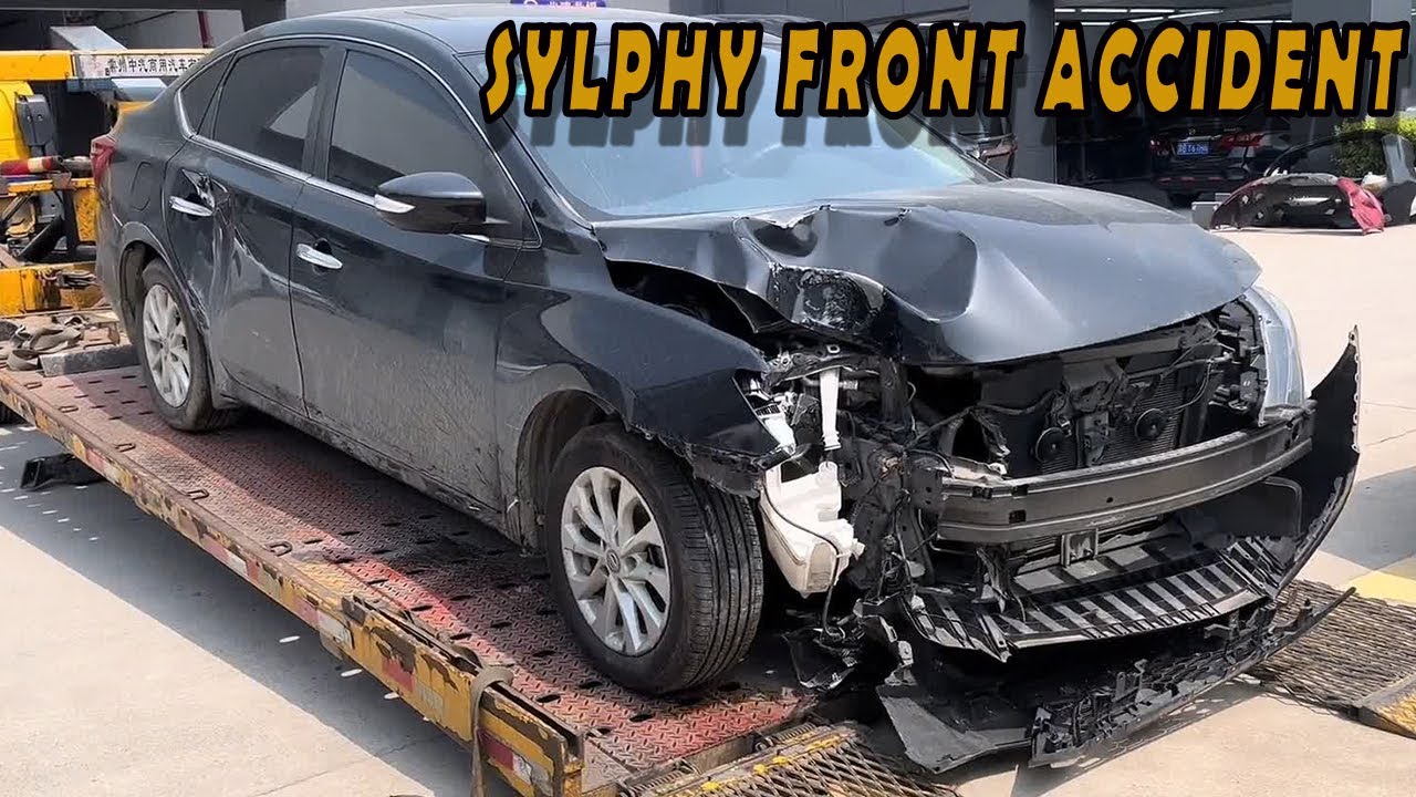 Молодой механик ремонтирует разбитый Nissan Sentra