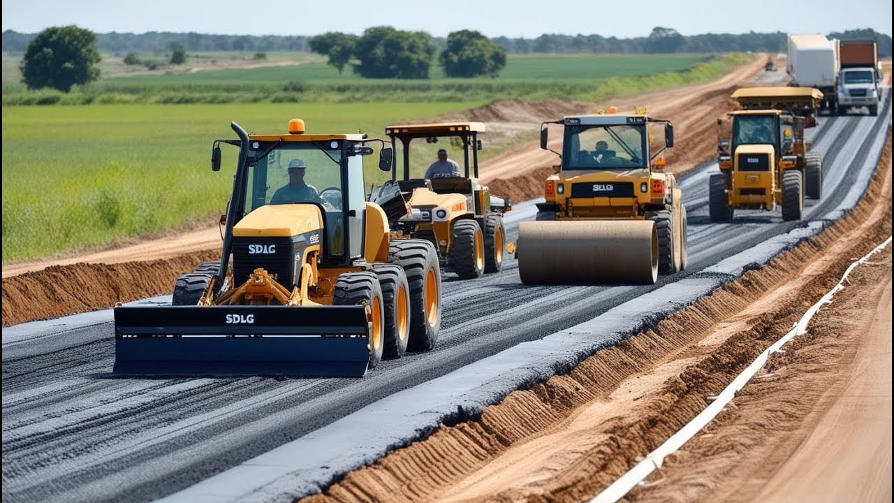 Amazing road construction in a rural area. The large yellow motor grader is working on a dirt road